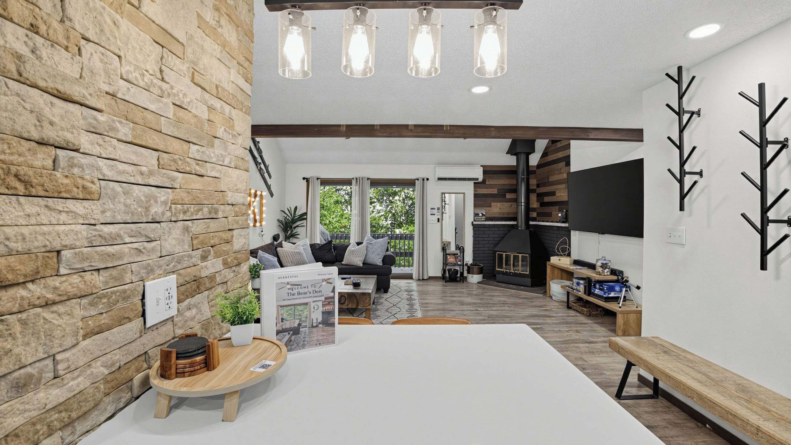 A modern interior with a stone wall, a wooden dining table, and a fireplace.