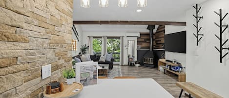 Ein modernes Interieur mit einer Steinwand, einem Holzesstisch und einem Kamin.