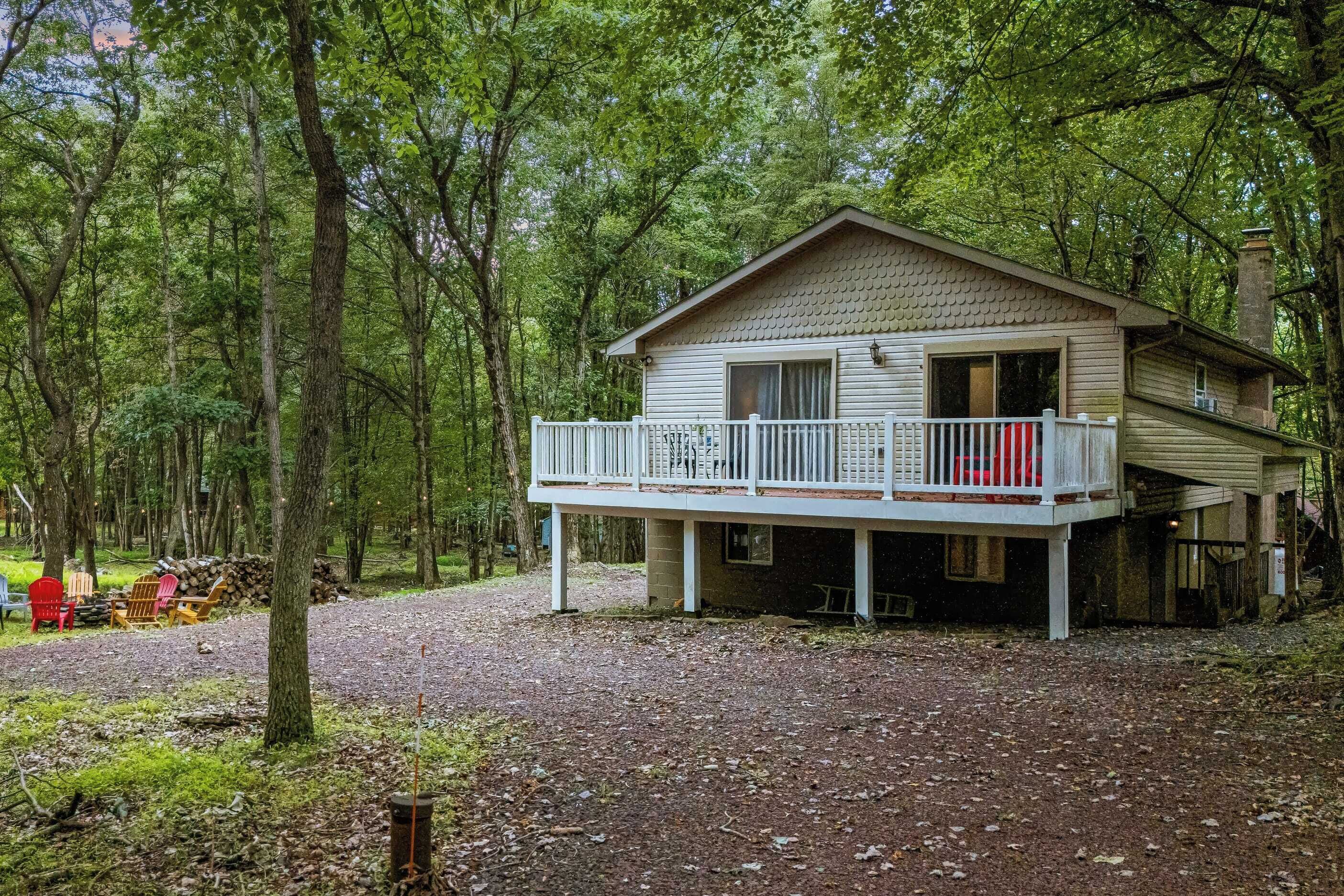 A cabin with a balcony, surrounded by trees.