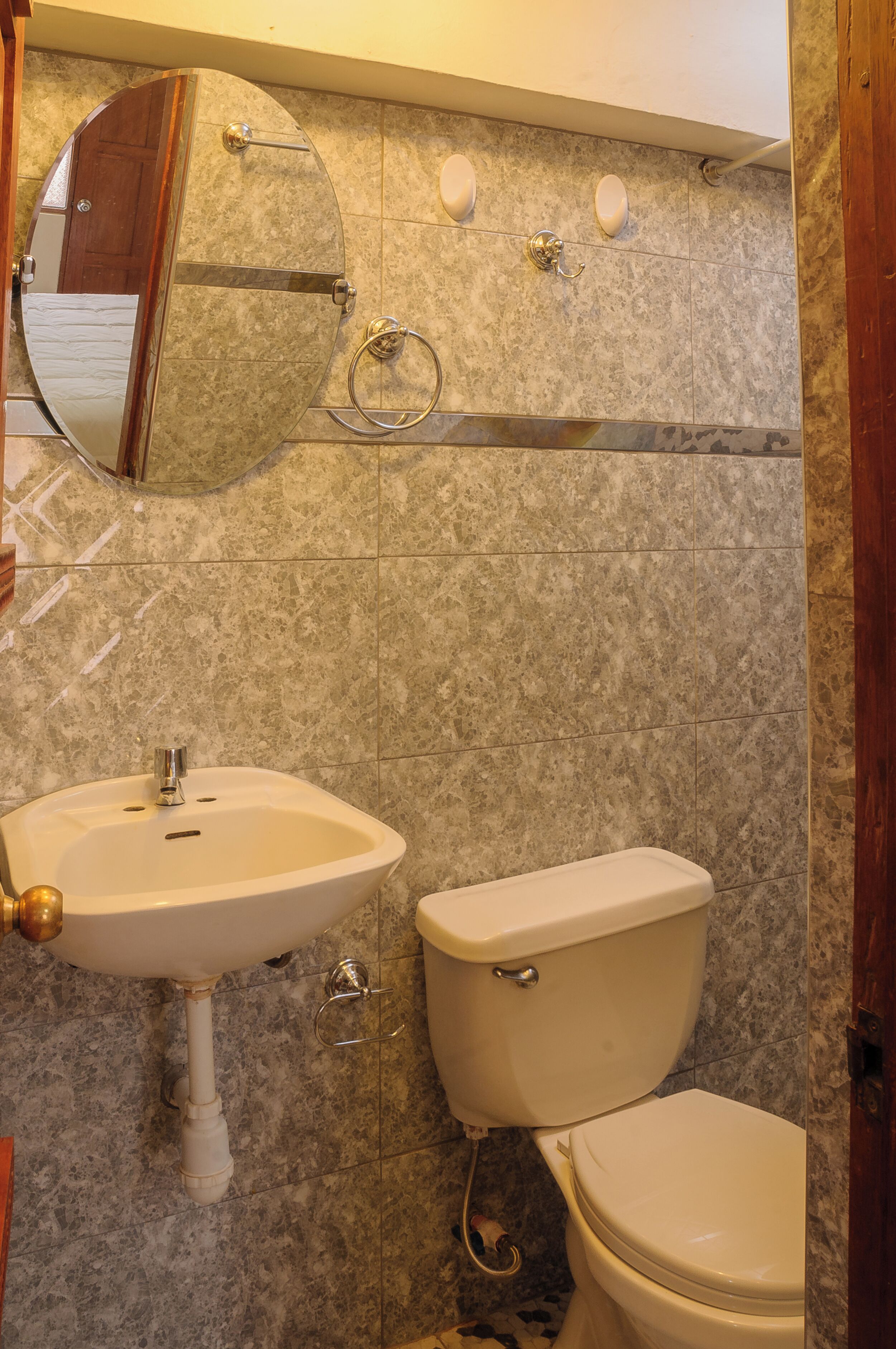 A bathroom with a sink, toilet, and a mirror.