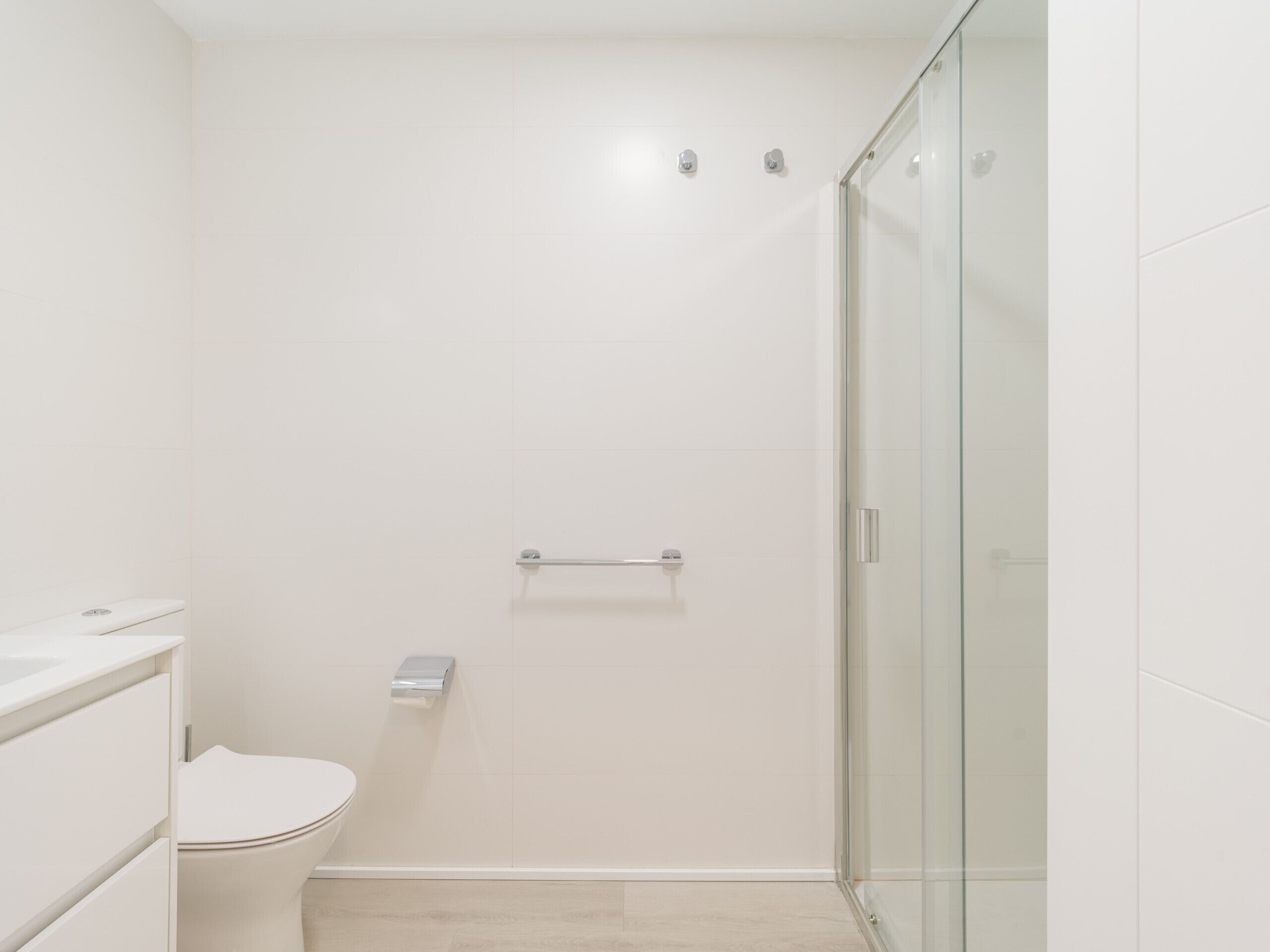Ein modernes Badezimmer mit Duschkabine aus Glas, Toilette und Waschtisch mit Spiegel.