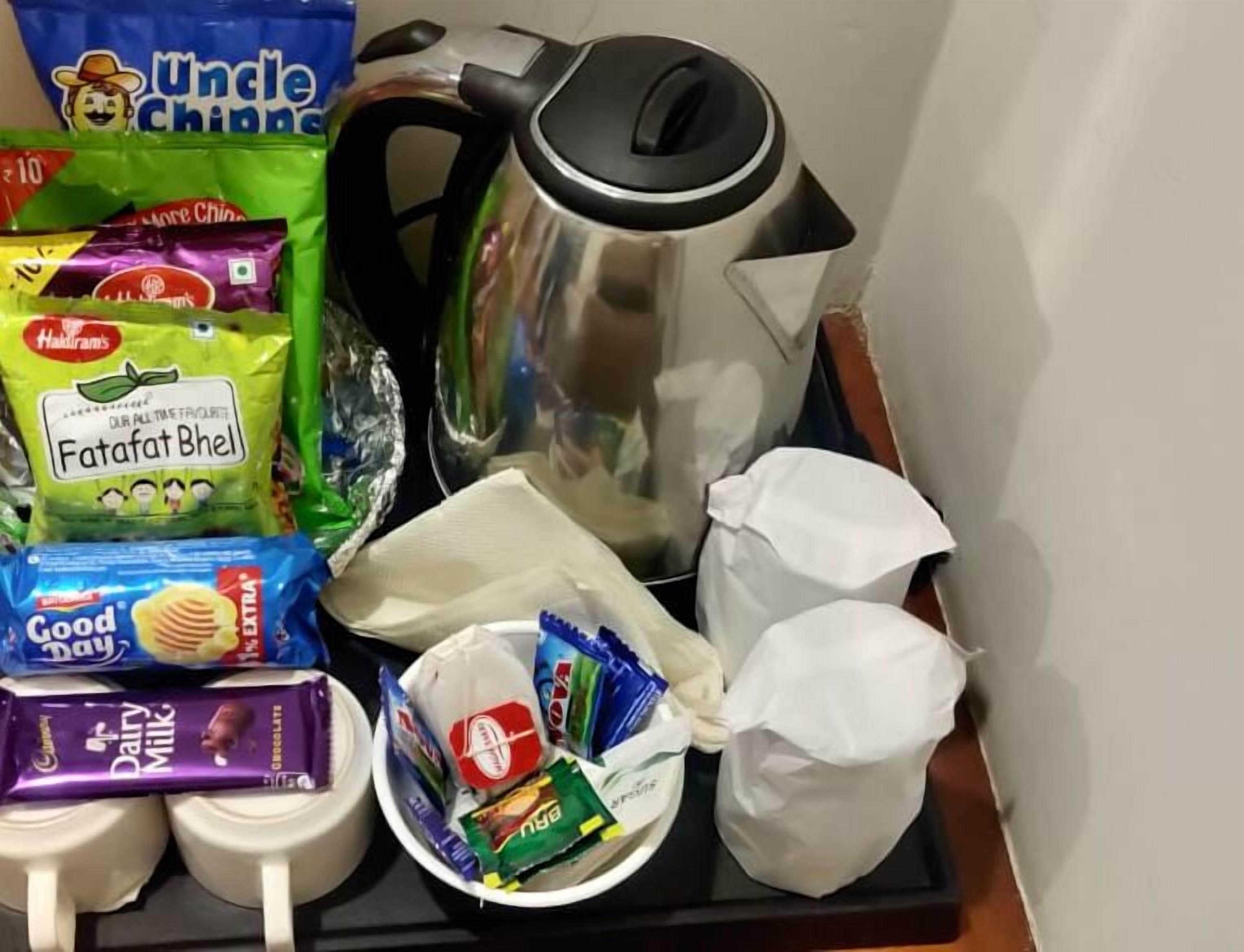 A tray with snacks, a kettle, and a milk carton.