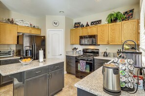 A modern kitchen with granite countertops, stainless steel appliances, wooden cabinets, and a coffee station. - Live, Work. Play & Relax | Scenic SW Vegas. (Las Vegas)