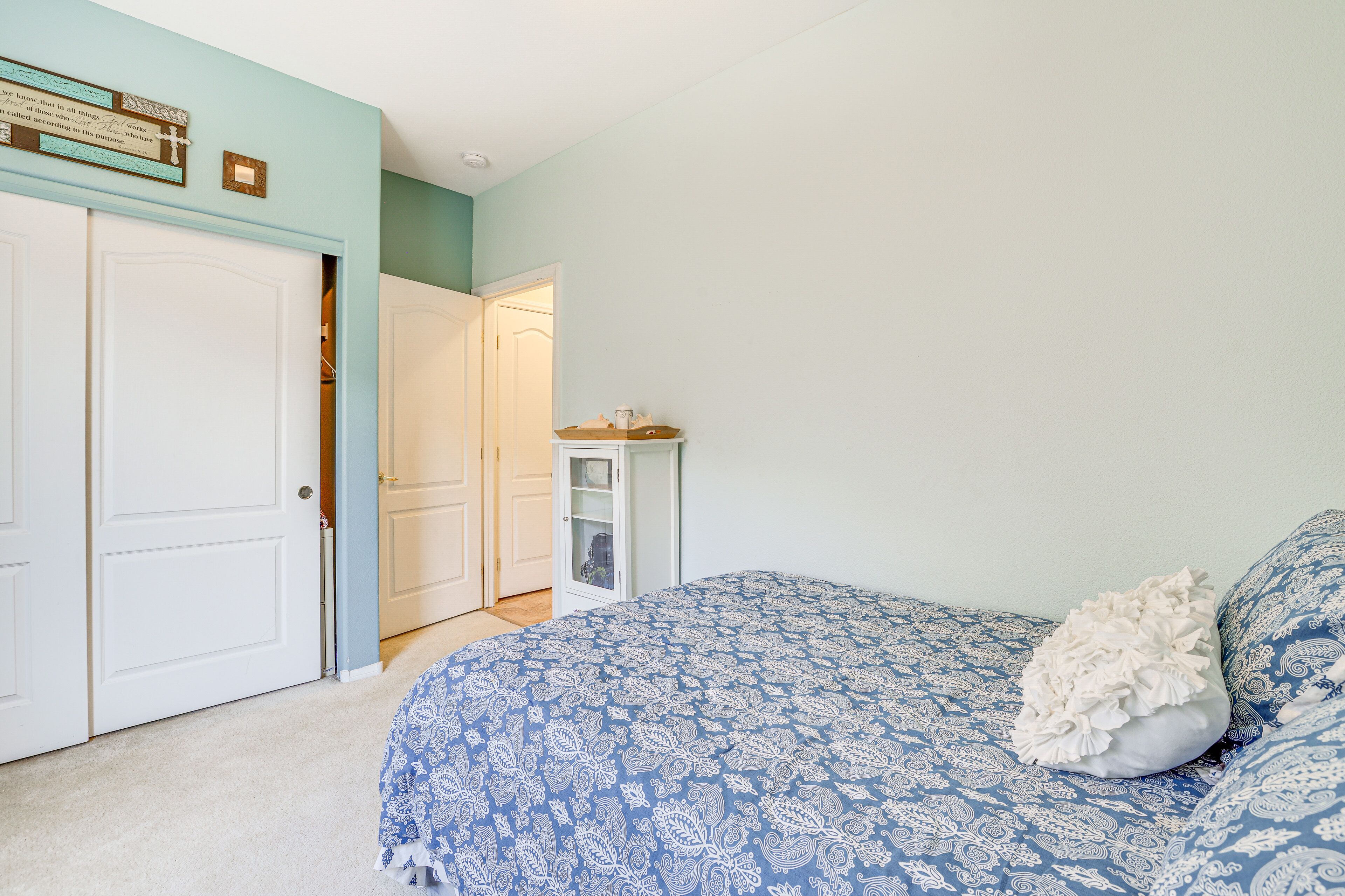 A bedroom with a bed, a nightstand, and a dresser.