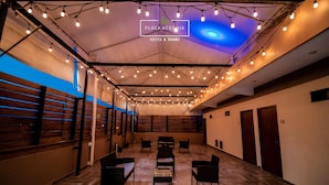 A spacious room with wooden flooring, multiple seating areas, and a ceiling adorned with string lights. - A03 SUPER CITY SUITE AT PLAZA ACEQUIA  (Cuautitlan Izcalli)