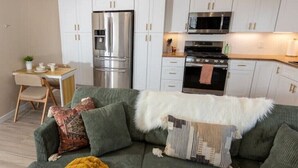 A compact living space with a sofa, a dining table, and a kitchenette.