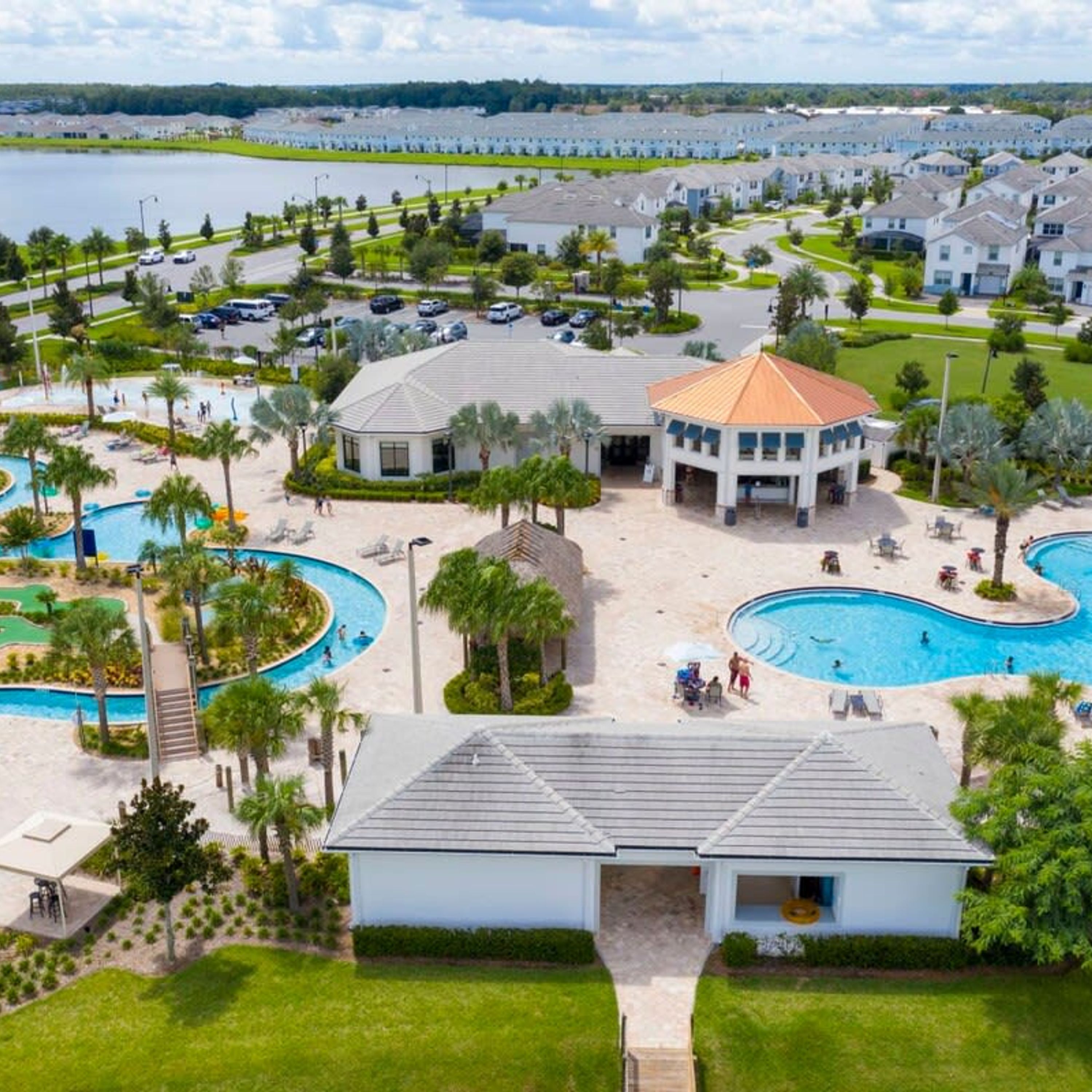 A resort with multiple swimming pools, a central building, and surrounding villas.