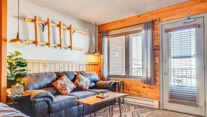 Ein gemütliches Wohnzimmer mit Ledersofa, Couchtisch aus Holz und einem gemusterten Teppich.