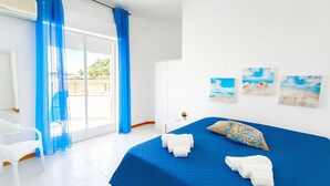 Habitación de hotel con cama, una silla, escritorio y vistas al exterior.