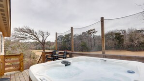 A hot tub on a wooden deck with a view of trees and a fence. - Kitty Hawk Apartment w/ Hot Tub - 1 Mi to Beach! (Kitty Hawk)