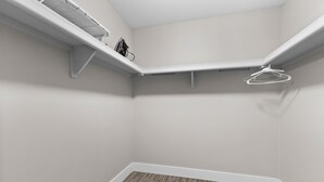 A corner room with a wooden floor, white walls, and built-in shelving with a drying rack. - Getaway in the Heart of the City! (Rochester Hills)