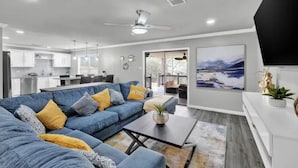 Una sala de estar moderna con un sofá azul, una mesa de centro y un televisor de pantalla plana.