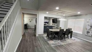 Una cocina moderna con comedor, suelo de madera y una escalera.