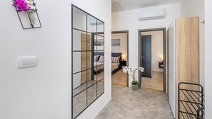 A hallway with a mirrored wall, a bed with a view, and a small plant. - Holiday house ASLAN with pool (Žestilac)