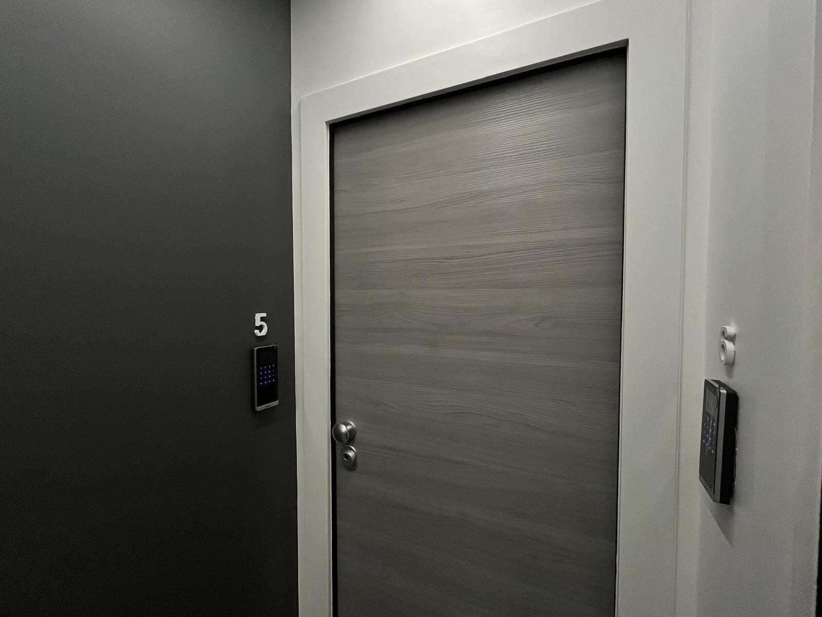 A modern elevator with a digital keypad and a door marked with the number 5.