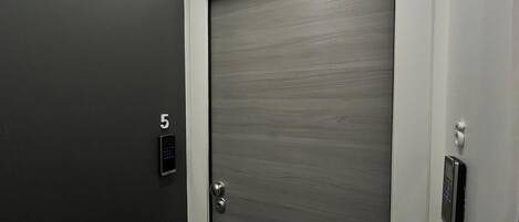 A modern elevator with a digital keypad and a door marked with the number 5.
