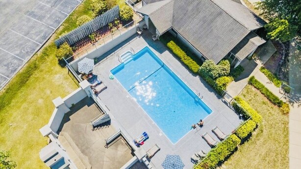 An aerial view of a residential property with a swimming pool, a covered patio, and a fenced garden area. - Walk-in condo with Golf Course View Near the Strip. NO STAIRS! (Branson)