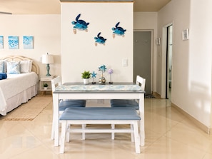 A bedroom with a bed, bedside table, lamp, and wall art.