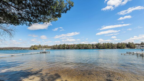 Un lago cristalino con muelles de madera y una orilla bordeada de bosque.