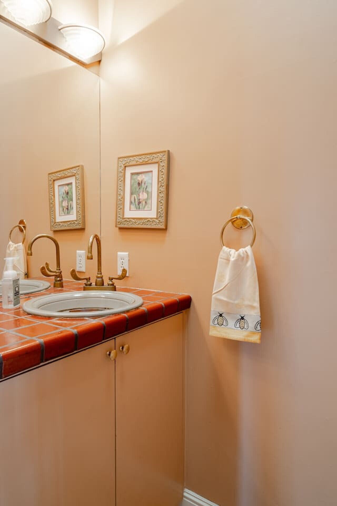 A bathroom with two sinks, a mirror, and a towel rack with a towel.