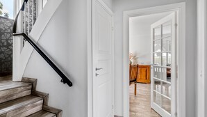 A staircase with a black handrail leading to a white door. - Nice home in Sydals with WiFi (Sydals)
