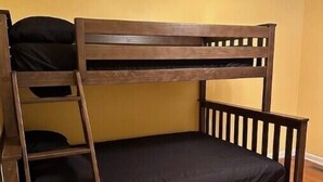 Een stapelbed met een ladder en een enkel matras.
