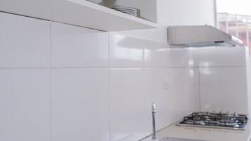 Een moderne keuken met witte kasten, een roestvrijstalen spoelbak en een afdruiprek.