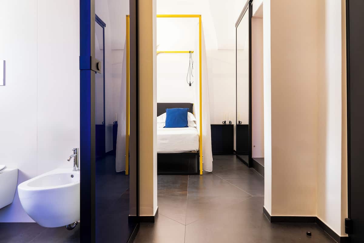 Una habitación de hotel moderna con cama, un bidé y un vestidor.