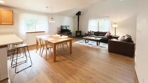 A spacious living area with a dining table, sofa, and fireplace.