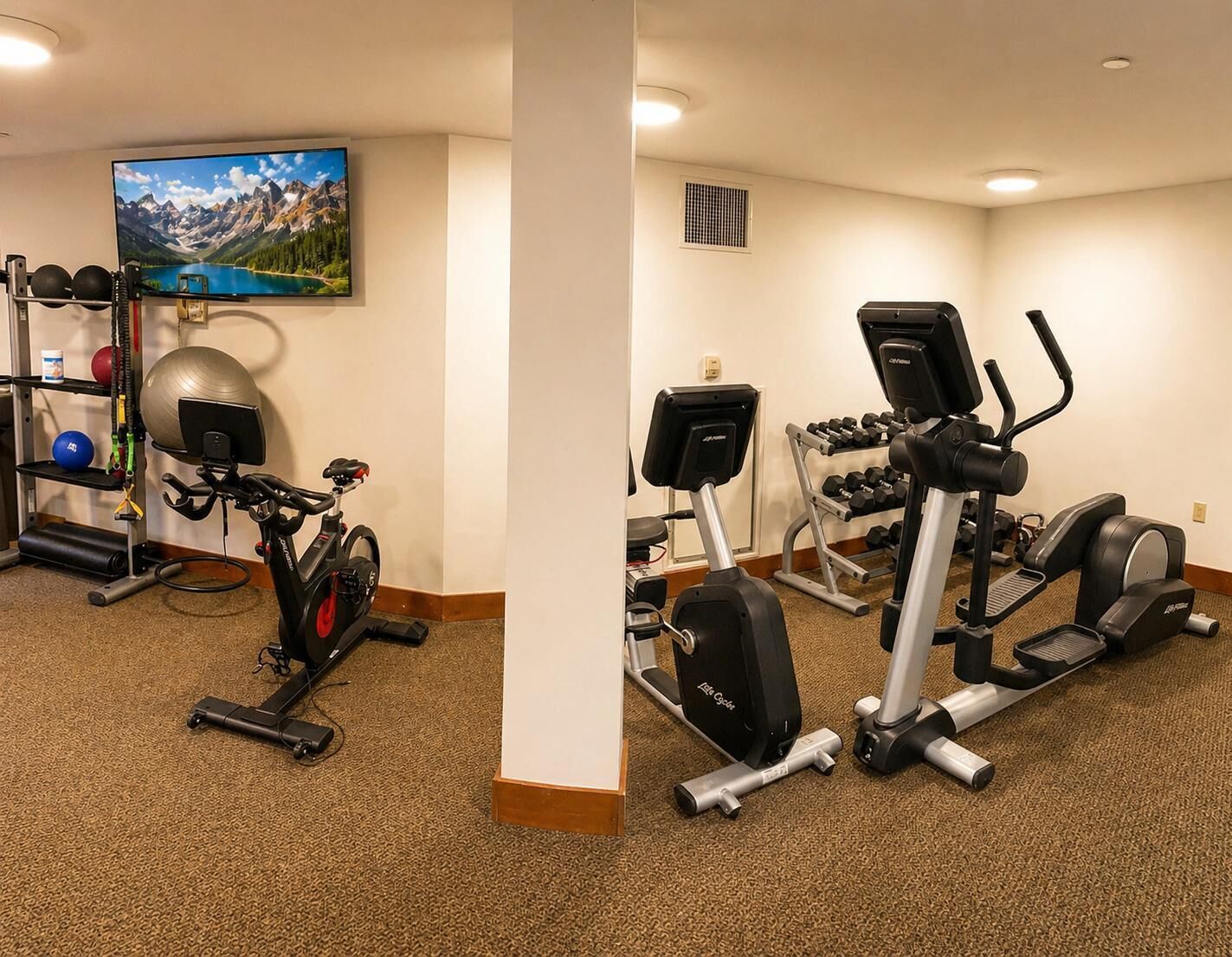 A home gym with a stationary bike, elliptical, and weight bench.