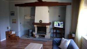 A living room with a fireplace, a television, and a sofa.