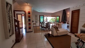 A spacious living area with a sofa, a dining table, and a fireplace. - Astral Nature (Pedra Verde (Domingas Dias) Ubatuba)