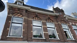 A multi-story brick building with large windows and decorative brickwork.