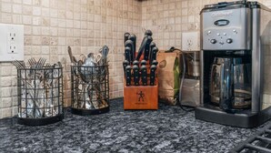 A kitchen with a coffee machine, knife block, and utensil holder. - Bright & Modern Home with Patio (Philadelphia)