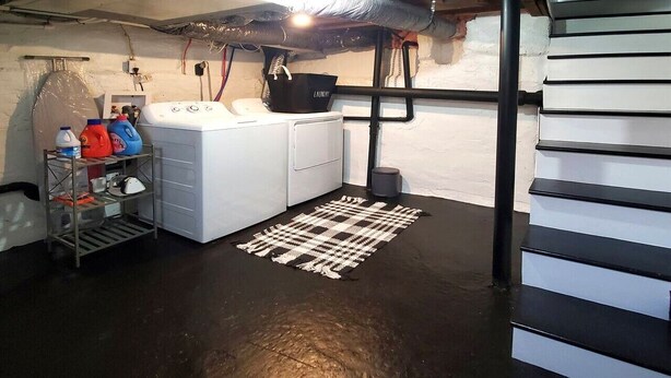 A laundry room with a washing machine, drying rack, and storage shelves.