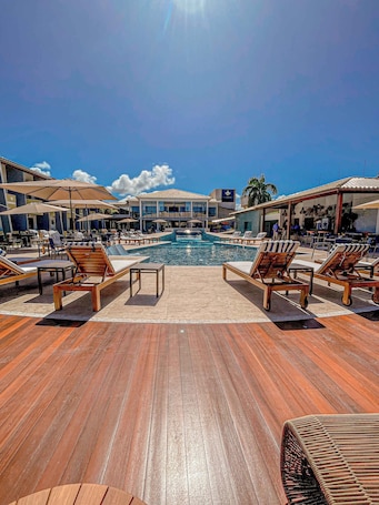 Una piscina al aire libre, camas de piscina gratis, sombrillas