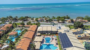 An aerial view of a resort with multiple buildings, a swimming pool, and a view of the ocean. - Príncipe do Muta Hotel Design (Santa Cruz Cabralia)