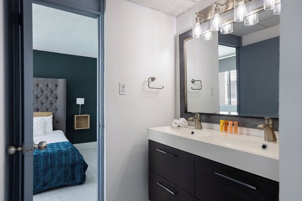 A modern bathroom with a large mirror, two sinks, and a vanity with drawers. - Brisa Marina 2BDR Pool Parking Beachside (Carolina)