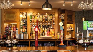 Um bar com diversas garrafas de bebidas e uma seleção de torneiras.