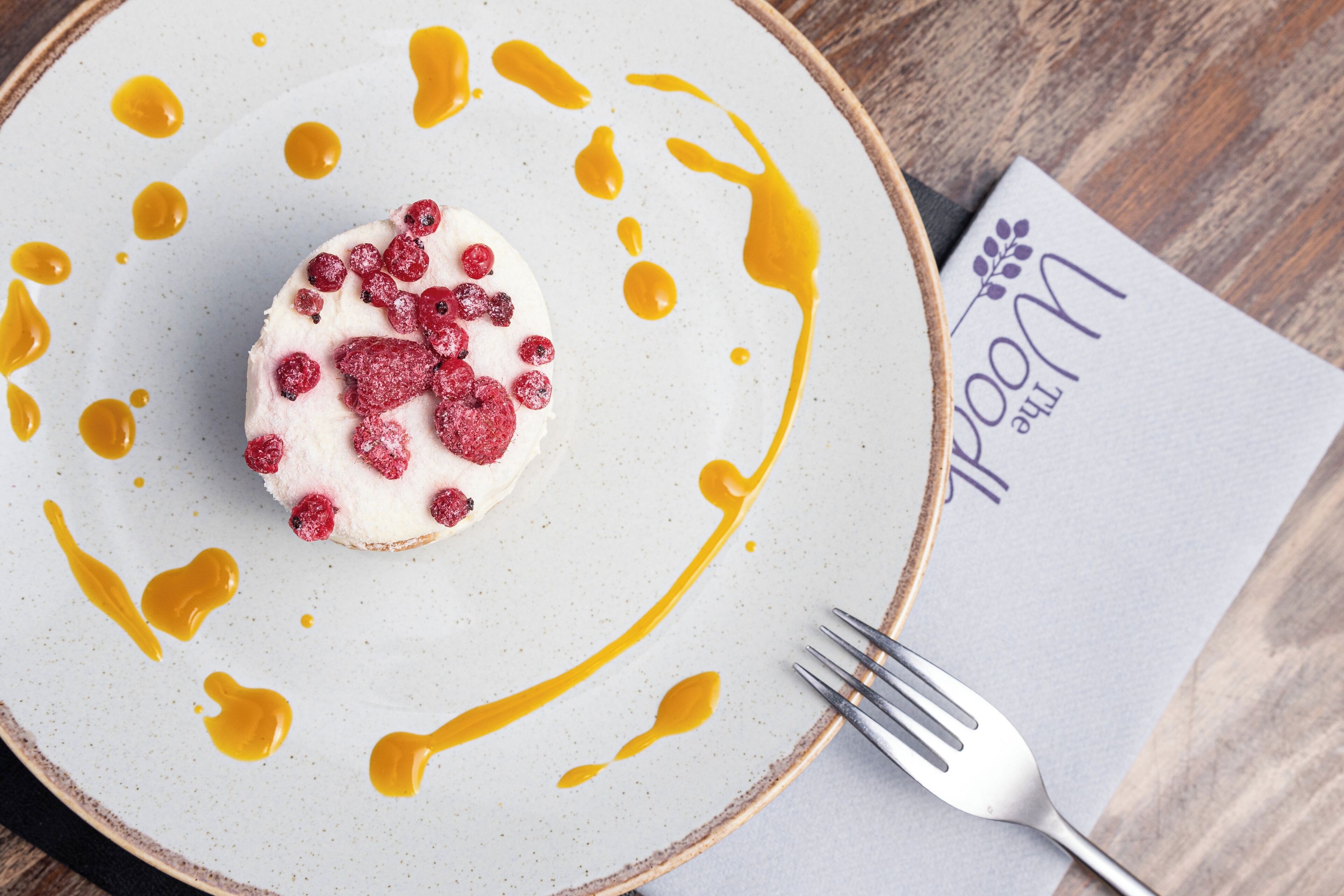 A dessert on a plate with a fork and napkin beside it.