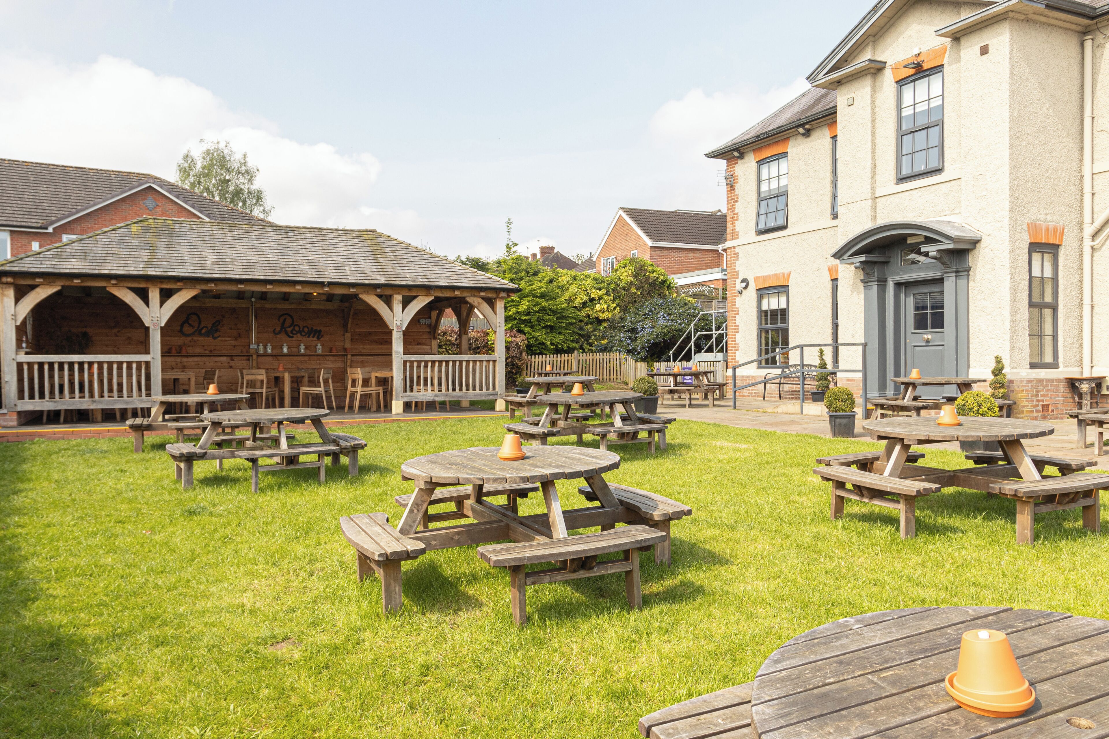 A courtyard with wooden picnic tables and a covered seating area.