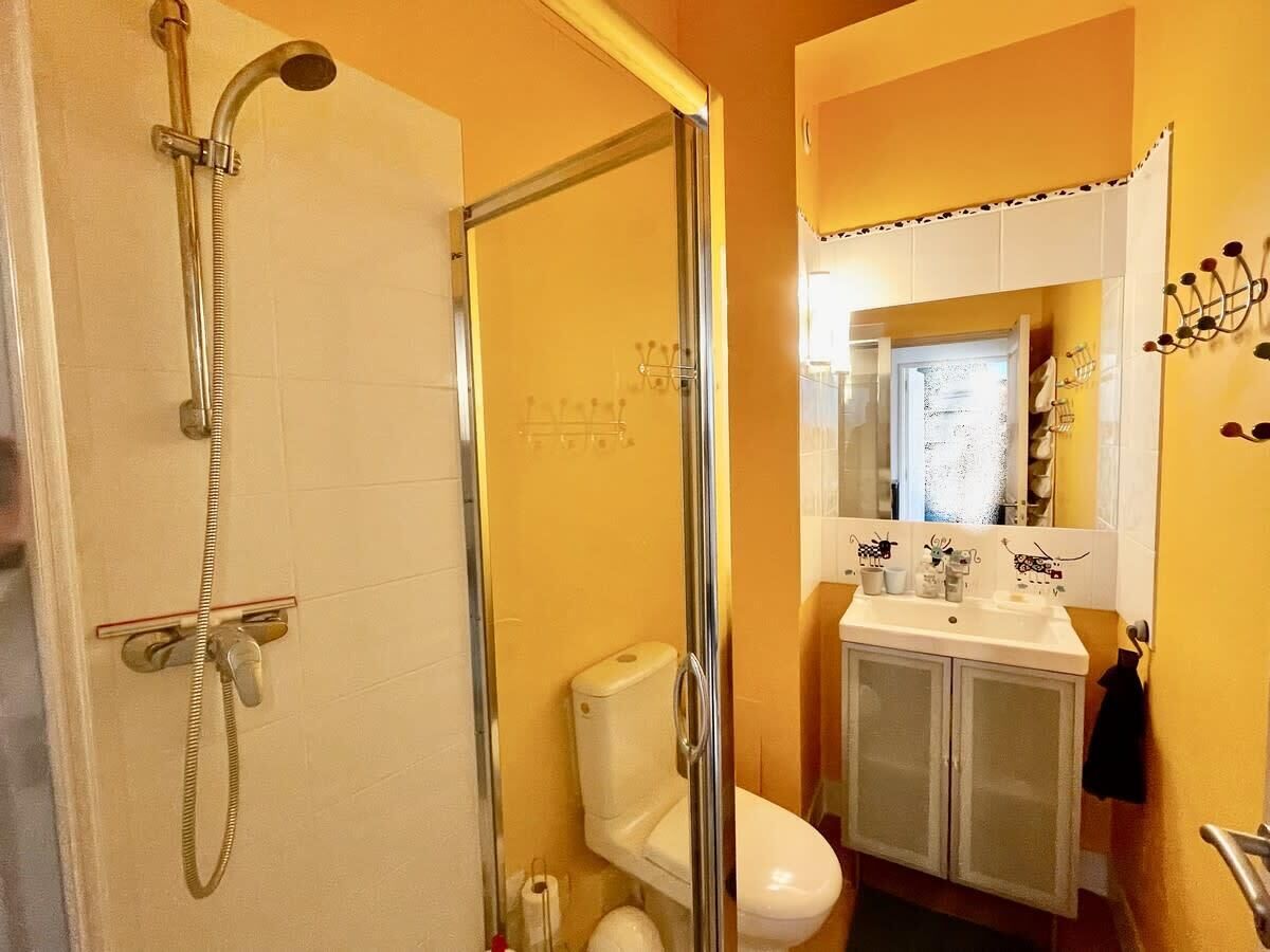 A bathroom with a shower, toilet, and sink.