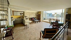 A spacious living area with a kitchen, dining area, and a balcony with a view. - Village house “Stella” (Saint-Cannat)