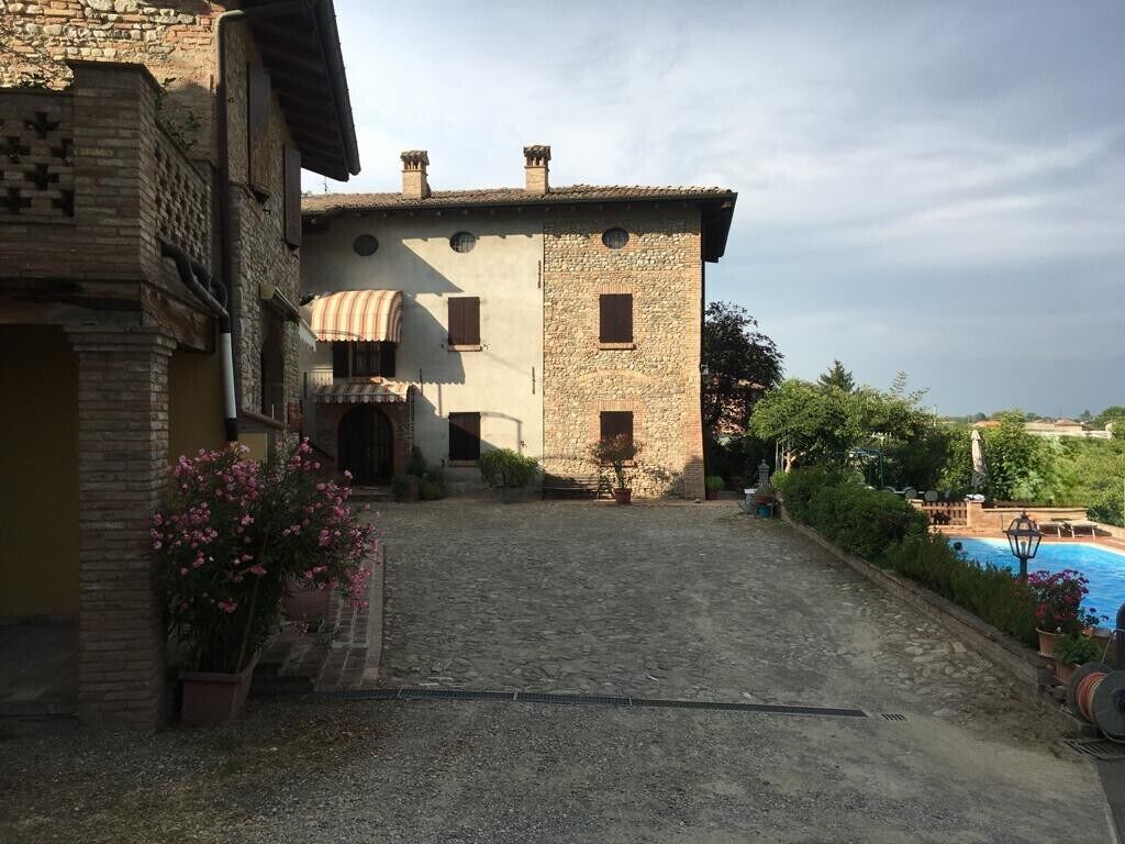 Ein Innenhof mit einem Steinhaus, einem Pool und Kübelpflanzen.