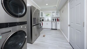 Une cuisine moderne dotée d’appareils électroménagers intégrés, de meubles blancs et d’un design épuré et minimaliste.