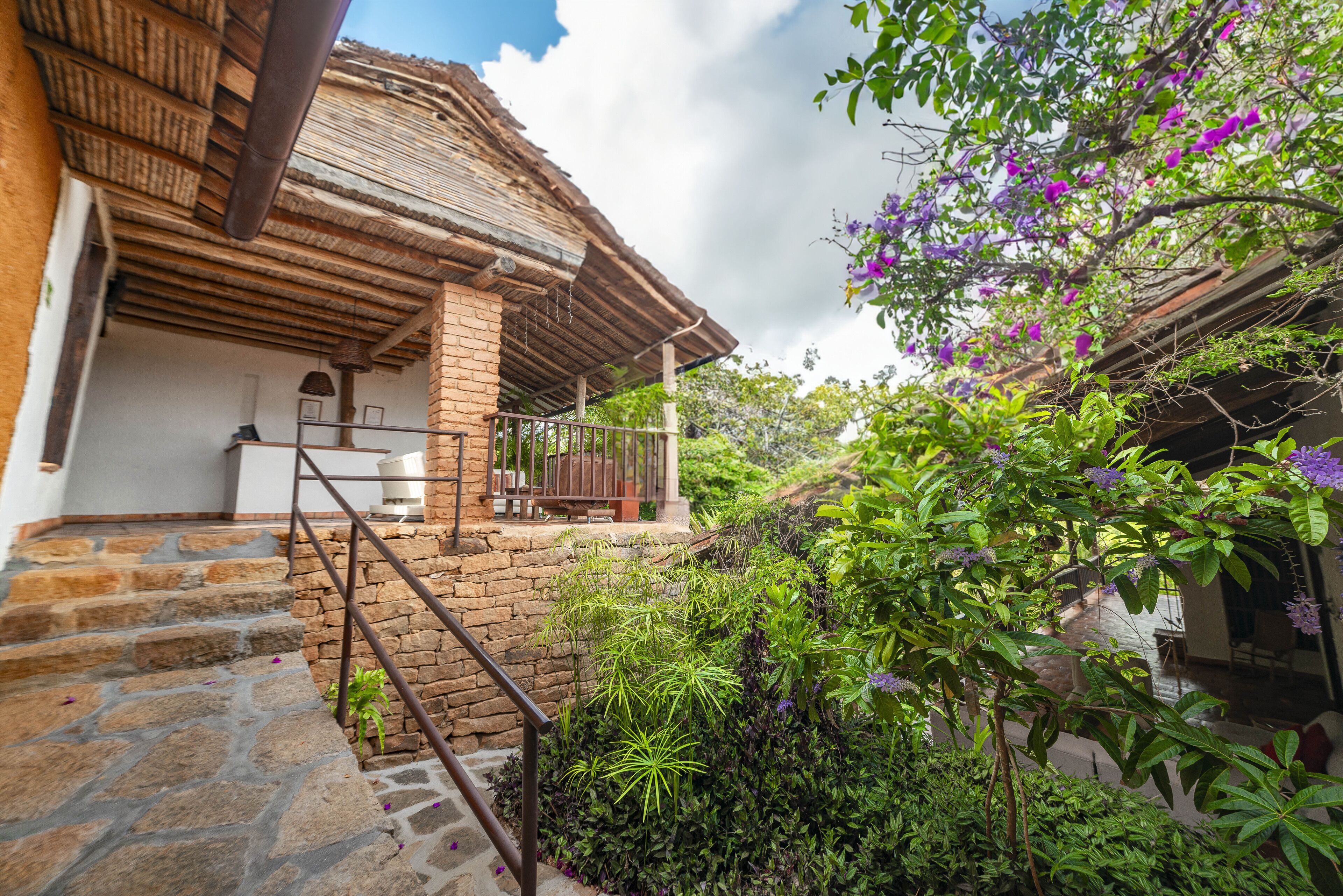 Una casa rústica con una escalera de piedra que da a un porche de madera.