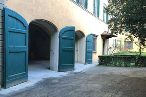Un bâtiment doté de trois portes en arc et d’un trottoir dallé.