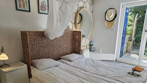 A bedroom with a bed, a nightstand, a lamp, a mirror, and a view of the outside. - Apartment Barbara with sea view (Njivice)
