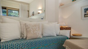 A bed with patterned bedding, a bedside table with a lamp, and a framed picture on the wall.