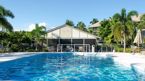 A swimming pool with a covered area, palm trees, and lounge chairs. - Waterfront condo with easy water access to world class fishing and sightseeing.  (Bokeelia)